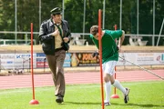 Staller (Helmfried von Lüttichau, links) befragt Stefan Schneider (Urs Fabian Winiger), wann er Andreas Sonnleitner das letzte Mal gesehen hat. Dabei muss er neben dem Fußballer herlaufen, der gerade mit einem Schlitten Krafttraining macht.