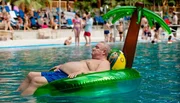 Krause (Horst Krause) lässt es sich bei  einem Ausflug ins Schwimmbad unter Palmen gut gehen.