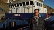 Captain Jake Anderson stands in front of his boat, the Saga.