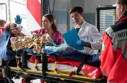 Die Assistenz&auml;rztin Viktoria Stadler (Isabella Krieger, 2.v.l.) erlebt einen Schockmoment, als ihr Bruder Anton (Lasse Stadelmann, l.) mit Brandverletzungen in die Notaufnahme eingeliefert wird. Ben Ahlbeck (Philipp Danne, 2.v.r. mit Komparse, r.) &uuml;bernimmt die weitere Behandlung.