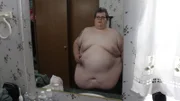 Aaron shirtless in front of a mirror.