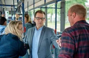 Lars Englen (Ingo Naujoks, M.) hat Mühe, im fahrenden Bus für Ruhe und Ordnung zu sorgen (mit Kompars:innen).