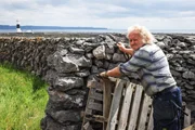 Der traditionelle Farmer Padraig P&oacute;il wohnt seit fast 70 Jahren auf Inisheer und baut im Zusammenleben mit der rauen Natur auf der Insel auch seine eigenen Steinmauern.