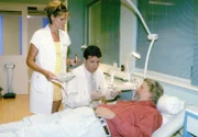 Roland Heilmann (Thomas Rühmann), assistiert von Schwester Yvonne (Maren Gilzer), untersucht Costa (Martin Huber).