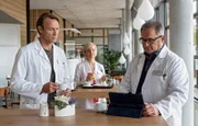 Dr. Martin Stein (Bernhard Bettermann, li.) fällt in einer kleinen Pause, die er mit Dr. Kathrin Globisch (Andrea Kathrin Loewig, mi.) verbringt, ein geschäftiger Hans-Peter Brenner (Michael Trischan, re.) auf. Als er ihm seine Hilfe anbietet, stellt sich heraus, dass Brenner gerade einen sehr schwierigen Patientenfall hat, der allerdings in Martins Fachgebiet fällt.