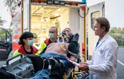 Udo von Wackerstein (Dirk Schoedon, liegend) wird von der Notärztin (Sarah Arntz, li.) in die Sachsenklinik eingeliefert. Dr. Martin Stein (Bernhard Bettermann, re.) staunt nicht schlecht, als er erzählt bekommt, dass von Wackerstein nun Schornsteinfeger ist.