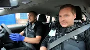 Police officers in car.