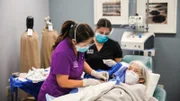 Dr. Lee is in the middle of removing Catherine Muller’s arm lipoma.