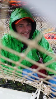 Spencer Moore, Deckhand on the Summer Bay, fixes the netting of a pot.