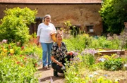 Eva Mundkowski (in weiß) und Melanie Seeber (schwarz/geblümt), sammeln Tischdeko im Garten