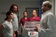 Dr. Keller (Thomas Limpinsel, r.) teilt den entsetzten Eltern Nadia (Lenis Adams, l.) und Felix Berger (Sebastian Fräsdorf, 2.v.l.) mit, dass ihr Baby umgehend operiert werden muss. Auch Hebamme Lena Lorenz (Judith Hoersch, 2.v.r.) und Praktikantin Celine Gollert (Paulina Rümmelein, M.) sind schockiert über die schlechte Nachricht.