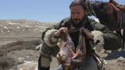 Hazen opening the mouth of a boiled yak head.