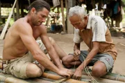 Hazen making a raft with local villager.