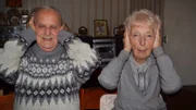 Ein Mann und eine Frau halten sich die Hände über die Ohren