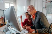Sabine (l.) und Dieter (r.) möchten gerne die Möglichkeiten der digitalen Welt besser nutzen können. Dafür gehen sie in ein DigitalCafe für Senioren in der Amerika Gedenkbibliothek in Berlin.