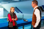 Uschi (Silke Popp) ist wenig begeistert davon, dass sie Winkler (Florian Stadler) in den Schießstand einweisen soll.