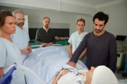 Ben Tewolde (Timo Fakhravar, r.) und Romys (Luisa Wietzorek, liegend) Vater Wolfgang Engert (Michael Schenk, M.) müssen sich verabschieden.