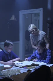 Recre- Neil and Stewart at table doing homework as mom consoles them.