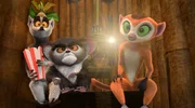(V.l.) King Julien, Maurice und Flora gucken sich in einer abgeschirmten Blockhütte ein geheimes Video an. Dabei erfährt King Julien vom mysteriösen Fußschemel-Programm!