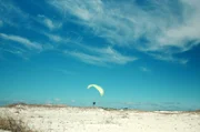 Paraglider Stan fliegt über die Smaragdküste. Da es am Strand keine Anhöhe gibt, von der er starten könnte, nutzt er einen Motor, um abzuheben.