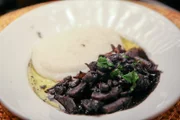 „Seppie col nero“ (Tintenfisch in seiner eigenen Tinte geschmort) ist eine Spezialität in der „Osteria al Cicheto“ in Venedig.