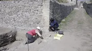 Die Archäologiestudentin Beatrice Lanteri und die Archäologieprofessorin Antonella Coralini untersuchen Beweise für ein mögliches Tieropfer, das unter einer Straße in Pompeji vergraben war.