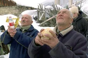 Die Männer bitten den Erzengel Michael um die Segnung ihrer Opfergaben, Schnaps und Brot.