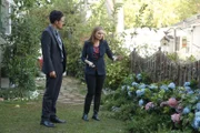Brennan (Emily Deschanel) erklärt Agent Aubrey (John Boyd), dass sich die Blumen im Garten des Opfers durch die blutgetränkte Erde verfärbt haben.  +++