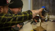 Rick Ness (l.) pouring gold as Bailey Carten reads scale, gold weigh