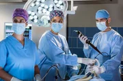 Dr. Leyla Sherbaz (Sanam Afrashteh, l.), Vivienne Kling (Jane Chirwa, M.) und Dr. Niklas Ahrend (Roy Peter Link, r.) untersuchen die Musikerin Kim Burisch mittels einer Bronchoskopie.