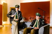Riedl (Paul Sedlmeir, rechts) will bei der Vernehmung seines Idols unbedingt dabei sein. Staller (Helmfried von Lüttichau) versucht sich derweil als Schlagzeuger.