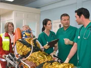 Dr. Heilmann (Thomas Rühmann, 2. von rechts), Dr. Eichhorn (Cheryl Shepard , 3. von rechts) und Dr. Brentano (Thomas Koch, rechts) nehmen in der Sachsenklinik den Busfahrer Günther Schulze (Komparse) auf, der von den Notärzten (Komparsin, links) in die Klinik gebracht wurde.