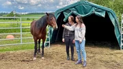 Anna (rechts) darf den wilden Mustang aus Amerika kennenlernen, den Lisa (links) gerade trainiert. Das Pferd ist erst seit drei Wochen in Deutschland und noch scheu und misstrauisch. (Lisa Eckstein)