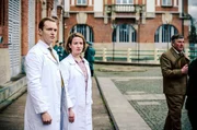 Dr. Ella Wendt (Nina Gummich, 2.v.l.) und Dr. Alexander Nowack (Max Wagner, l.) schauen entsetzt zum Humboldhafen - der erste Mauertote wird aus dem Wasser geborgen.