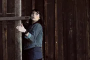 Nina (Andrea Schmitt) sucht bei der Waldhütte nach einem Versteck.