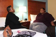 Kelly is on a hotel bed with a friend.