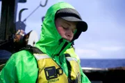 Cornelia Marie Greenhorn, Taylor Jensen, is decked out in green rain gear, ready to work.