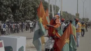 In Burkina Fasos Hauptstadt Ouagadougou posieren Unterstützer mit den Flaggen der Allianz der Sahelstaaten und der Flagge Russlands.