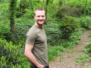 Justin Barber standing in the woods (recreation).