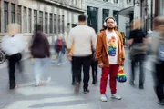 Nico-Rapahel (33) trägt seine geräuschreduzierenden Kopfhörer um sich abzuschirmen von den Menschen und der Geräuschkulisse . Der 33-jährige liebt es bunt. Seine Regenbogentasche hat er immer dabei.