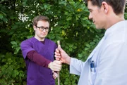 Als Dr. Ben Ahlbeck (Philipp Danne, r.) Olli (Arne Kertész, l.) mit einem Stock herumstochernd im Gebüsch auffindet, fängt er sich an zu wundern, was es mit dem seltsamen Verhalten auf sich hat.