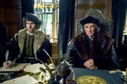 Cromwell (Mark Rylance, re.) und Wriothesley (Harry Melling, li.) führen ein ernstes Gespräch mit Lady Meg Douglas und ihrer Zofe (beide nicht im Bild).