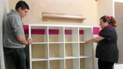 Tauschmutter Nicole (38) und René schieben ein Regal an die Wand Tauschmutter Nicole (38) und René schieben ein Regal an die Wand