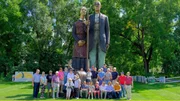 Die Reisegruppe in Anamosa Iowa vor einer Skulptur zur Erinnerung an den Künstler Grant Wood.