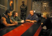 (v.li.:) Teal'C (Christopher Judge), Daniel (Michael Shanks), O'Neill (Richard Dean Anderson) und Carter (Amanda Tapping) überlegen, wie sie gegen die Organisation 'Trust' vorgehen können...
