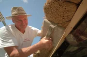 Reetdachdecker Walter Epting gestaltet die Traufe des Reetdachs der Mühle im Schwarzwald.