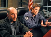 Daniel (Michael Shanks, r.) versucht zu klären, woher der einfache Frisör Joe Spencer (Dan Castellaneta) so viel über SG-1 weiss.