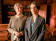 "Agatha Christie's Poirot", "Die Katze im Taubenschlag." Im renommierten Mädchenpensionat Meadowbank werden Töchter aus reichen Familien und eine ausländische Prinzessin auf ihre Zukunft vorbereitet. Poirot ist mit der Schulleiterin befreundet und eingeladen die Abschlussrede zu halten. Nach der anschließenden Feier bittet Miss Bulstrode Poirot seine Fähigkeit zur Menschenbeobachtung dazu einzusetzen, in der Lehrerschaft eine Nachfolgerin für das Amt der Schulleiterin auszuwählen. Poirot stimmt bereitwillig zu, ohne zu ahnen, dass in der darauffolgenden Nacht ein grausamer Mord geschehen wird. Die sadistische Sportlehrerin Grace Springer wird in der abseits gelegenen Turnhalle von einem Wurfspeer durchbohrt aufgefunden. Schnell ist klar, dass sich dieser Zwischenfall auf das Renommee des Internats auswirken wird. Zwar versucht Miss Bulstrode das Geschehene nicht an die Öffentlichkeit dringen zu lassen, aber nach einem Mordversuch, der Enttarnung eines MI5-Agenten und einem weiteren Mord an der Französischlehrerin Mademoiselle Blanche, lässt sich der Aderlass der Schülerschaft nicht mehr aufhalten. Nun ist es an Poirot, den Mörder zu überführen und so die Reputation der Schule wiederherzustellen. Im Bild (v.li.): Susan Wooldridge (Miss Chadwick), Harriet Walter (Miss Bulstrode).
