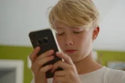 NZZ Format Aufwachsen ohne Smartphone - Ist eine Kindheit ohne Tiktok und Co. möglich? John mit Smartphone