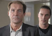 Zwar nimmt der Wirtschaftsprüfer Weber (John Friedmann, rechts) Dr. Fährmann (Michael Lesch) die Sorge um die Jahresabschlussbilanz. Doch Fährmanns Freude hält sich in Grenzen: Er weiß, dass sein Stuhl auch mit guter finanzieller Bilanz wackelt.